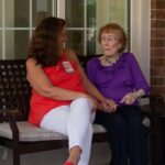 Meghan sits outside with a resident at Paul's Run.