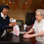 A Sister and a fellow resident complete a purchase at the Paul's Run general store.