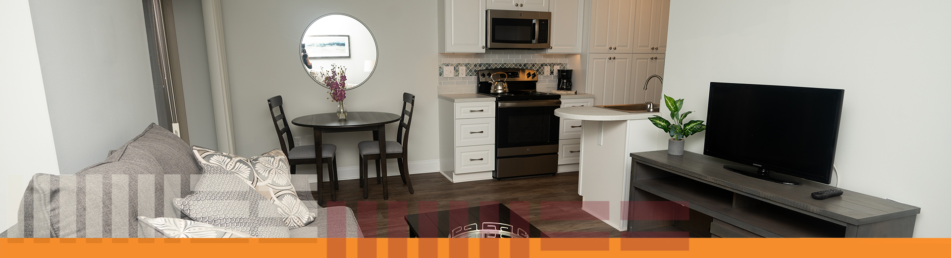 senior community studio apartament showing kitchen ara, dining table for two, sofa, coffee table, tv stand and 32