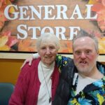 Long-time volunteer Philip and his sister Pat pose in front of our "General Store" sign at Paul's Run