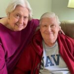 Couple smiles while sitting in their Independent Living apartment at Paul's Run
