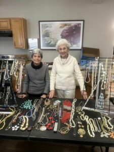 Two residents stand in front of the jewelry table at the Paul's Run holiday bazaar.