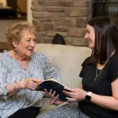 A resident sits and reads the Bible with the Director of Spiritual Care at Paul's Run.