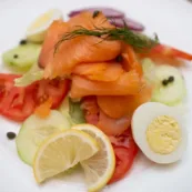 Smpked salmon with tomato, lemon, and hardboiled egg.