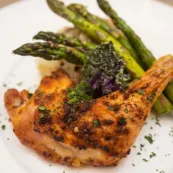 Residents enjoy seasoned grilled chicken with a side of asparagus.