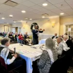 Man conducts Paul's Run Bell Choir during a performance at The Manor at York Town
